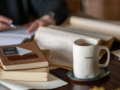 Think coffee cup on desk covered in books